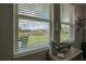 A serene view showcases a lush green landscape and a tranquil pond, framed by a sunlit window with white blinds at 9672 Ivory Dr, Ruskin, FL 33573