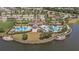 Aerial view of a community clubhouse with pools and outdoor seating areas, set along the scenic water's edge at 9814 Quadrangle Ct, Sun City Center, FL 33573