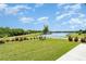 Lush backyard with serene lake views, complemented by well-maintained landscaping at 9814 Quadrangle Ct, Sun City Center, FL 33573