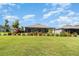 Expansive backyard showing a large grassy area, with garden beds surrounding the home and landscaping at 9814 Quadrangle Ct, Sun City Center, FL 33573