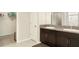 Bathroom features double sinks, a granite countertop, dark cabinetry, and a walk-in closet at 9814 Quadrangle Ct, Sun City Center, FL 33573