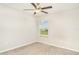 Neutral bedroom features a ceiling fan and a window with views of the blue sky at 9814 Quadrangle Ct, Sun City Center, FL 33573