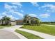 Charming single-story home featuring a well-manicured lawn, and an attached two-car garage at 9814 Quadrangle Ct, Sun City Center, FL 33573