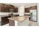 Features a kitchen island with granite countertops, stainless steel appliances, and modern fixtures at 9814 Quadrangle Ct, Sun City Center, FL 33573