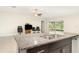Modern kitchen island features stainless steel sink, granite countertop, and stylish cabinetry at 9814 Quadrangle Ct, Sun City Center, FL 33573