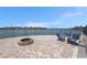 Waterfront patio with brick pavers, lake views, outdoor fire pit and Adirondack chairs create an ideal spot for outdoor relaxation at 9814 Quadrangle Ct, Sun City Center, FL 33573