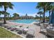 Community pool area featuring a lap pool, lounge chairs, and a spacious clubhouse at 9814 Quadrangle Ct, Sun City Center, FL 33573