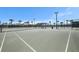 Well-maintained community tennis courts with net, fencing, and palm trees providing shade at 9814 Quadrangle Ct, Sun City Center, FL 33573