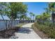 Scenic community walkway by the lake, featuring a black fence, mature trees, and lush landscaping at 9814 Quadrangle Ct, Sun City Center, FL 33573