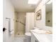 Bright bathroom featuring a shower with safety bars, a white vanity, and marble floors at 3078 Eastland Blvd # 205, Clearwater, FL 33761