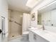Bright bathroom featuring a shower with safety bars, a white vanity, and marble floors at 3078 Eastland Blvd # 205, Clearwater, FL 33761