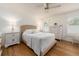 Bright bedroom with hardwood floors, white furniture, a ceiling fan and a window at 3078 Eastland Blvd # 205, Clearwater, FL 33761