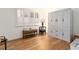 Bright bedroom featuring laminate wood floors, white shutters and a white wardrobe at 3078 Eastland Blvd # 205, Clearwater, FL 33761