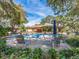 Beautiful community pool surrounded by lush greenery, lounge chairs, and patio seating at 3078 Eastland Blvd # 205, Clearwater, FL 33761