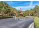 Community entrance with lush landscaping, decorative stop sign, and American flag flying at half mast at 3078 Eastland Blvd # 205, Clearwater, FL 33761