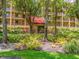 The community building showcases lush landscaping, mature trees, and a charming red tile roof at 3078 Eastland Blvd # 205, Clearwater, FL 33761