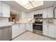 Bright kitchen features white cabinets, stainless steel appliances, and a sunlit skylight at 3078 Eastland Blvd # 205, Clearwater, FL 33761