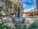 The community pool features a table with umbrella and multiple lounge chairs for relaxing poolside under blue skies at 3078 Eastland Blvd # 205, Clearwater, FL 33761
