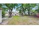 Expansive backyard with mature trees, partial fencing, and ample space for outdoor recreation at 1005 45Th W St, Bradenton, FL 34209