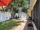 Charming backyard with a wooden walkway, storage shed, grill, mature trees, and partial fence at 1006 Tropical Dr, Bradenton, FL 34208