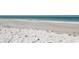 Scenic beach view with turquoise water, white sand, and gentle waves at 1006 Tropical Dr, Bradenton, FL 34208