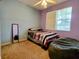 Bright bedroom featuring plush carpet, a comfortable bed, ceiling fan, and a window for natural light at 1006 Tropical Dr, Bradenton, FL 34208