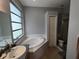 Relaxing bathroom featuring a soaking tub, privacy window, and a separate toilet and shower stall at 1006 Tropical E Dr, Bradenton, FL 34208