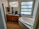 Bright bathroom with a double sink vanity, large mirror, soaking tub and light fixtures at 1006 Tropical E Dr, Bradenton, FL 34208
