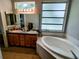 Bright bathroom with a double sink vanity, large mirror, soaking tub and light fixtures at 1006 Tropical E Dr, Bradenton, FL 34208
