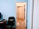 Hallway with light blue walls leading to a bedroom and bathroom, with a black chair in the foreground at 1006 Tropical E Dr, Bradenton, FL 34208