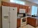Kitchen featuring modern appliances, light oak cabinets, and plenty of natural light at 1006 Tropical E Dr, Bradenton, FL 34208