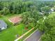 Aerial view of a home with a well-maintained lawn, mature trees, and a quiet residential street at 1015 Hastings Ct, Lutz, FL 33548