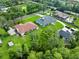 Aerial view highlighting a home with a spacious yard, mature trees, and proximity to neighborhood amenities at 1015 Hastings Ct, Lutz, FL 33548