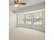 Well-lit room featuring large windows with blinds, carpet flooring, and a ceiling fan at 1015 Hastings Ct, Lutz, FL 33548