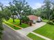 Aerial view of home, highlighting the expansive lawn, mature trees and driveway at 1015 Hastings Ct, Lutz, FL 33548