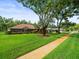 Single-story home featuring mature trees, manicured landscaping, and a well-maintained lawn at 1015 Hastings Ct, Lutz, FL 33548