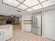 View of the kitchen with stainless steel refrigerator and view of the brick fireplace at 1015 Hastings Ct, Lutz, FL 33548