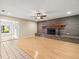 Inviting living room featuring hardwood floors, a cozy brick fireplace, and ample natural light at 1015 Hastings Ct, Lutz, FL 33548