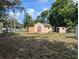 A look at the exterior and large yard of this home, surrounded by mature trees at 1028 E 93Rd Ave # A, Tampa, FL 33612
