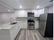 Modern kitchen features stainless steel appliances, granite countertops, and sleek white cabinetry at 1028 E 93Rd Ave # A, Tampa, FL 33612