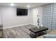 A well-lit living room with a large screen TV, stylish coffee table and open space at 1028 E 93Rd Ave # A, Tampa, FL 33612