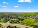 An aerial view showing a community with a playground, dog park, basketball court and residences in the distance at 10909 Kirkwall Port Dr, Wimauma, FL 33598