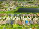 Aerial view showcases a neighborhood with houses bordering a serene lake at 10909 Kirkwall Port Dr, Wimauma, FL 33598
