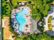 An aerial view showcases a uniquely shaped community pool with ample lounge seating and a nearby playground at 10909 Kirkwall Port Dr, Wimauma, FL 33598