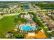 An aerial view displays a Primary-planned community with a pool, playground, dog park, and beautiful landscaping at 10909 Kirkwall Port Dr, Wimauma, FL 33598