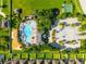 An aerial view of the community pool, playground, basketball court and lush green areas with surrounding homes at 10909 Kirkwall Port Dr, Wimauma, FL 33598