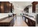 Modern kitchen with stainless steel appliances, dark wood cabinets, and an open layout at 10909 Kirkwall Port Dr, Wimauma, FL 33598