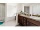Elegant main bathroom with dual vanities, a soaking tub, and a separate shower at 10909 Kirkwall Port Dr, Wimauma, FL 33598