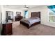 Cozy main bedroom with a ceiling fan, dark wood furniture, and ample natural light at 10909 Kirkwall Port Dr, Wimauma, FL 33598