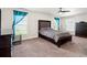 Comfortable bedroom features a ceiling fan, carpet flooring and bright blue accents at 10909 Kirkwall Port Dr, Wimauma, FL 33598